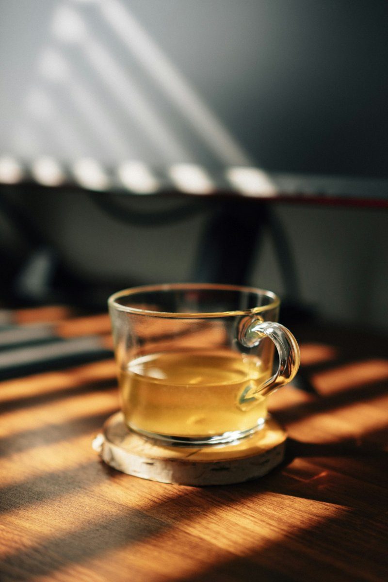 Glas Tee im Morgenlicht auf einem Holztisch